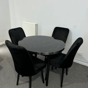 Round black table with four black upholstered chairs on gray carpet.