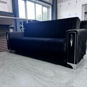 Charcoal Charm Sofa Bed with velvet upholstery and metallic accents in an industrial setting.