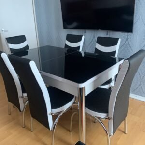 Modern ClearSpan Dining Set with a black glass table and six black and white chairs.