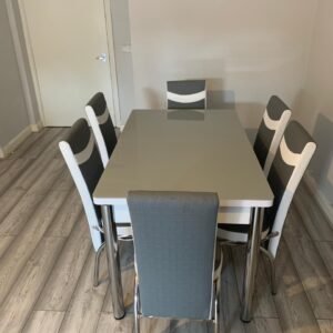ClearSpan Dining Set with a gray table and six matching gray and white chairs in a modern dining room.