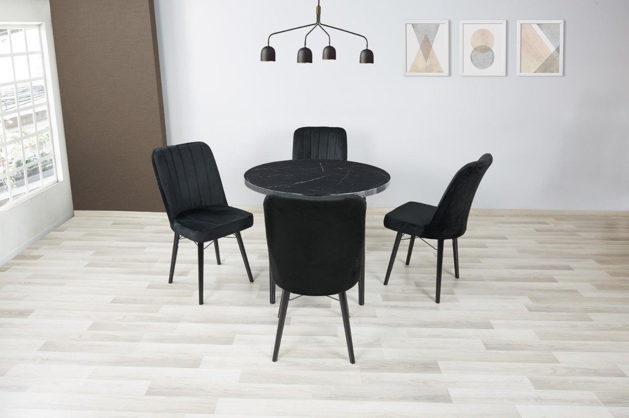 Modern dining area with a round black table, four black chairs, and minimalist decor.