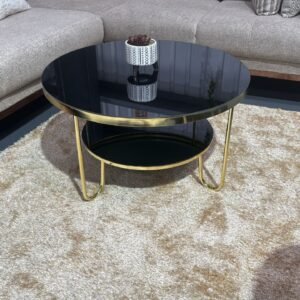 Round Everett Coffee Table with black glass top and gold frame in a modern living room.
