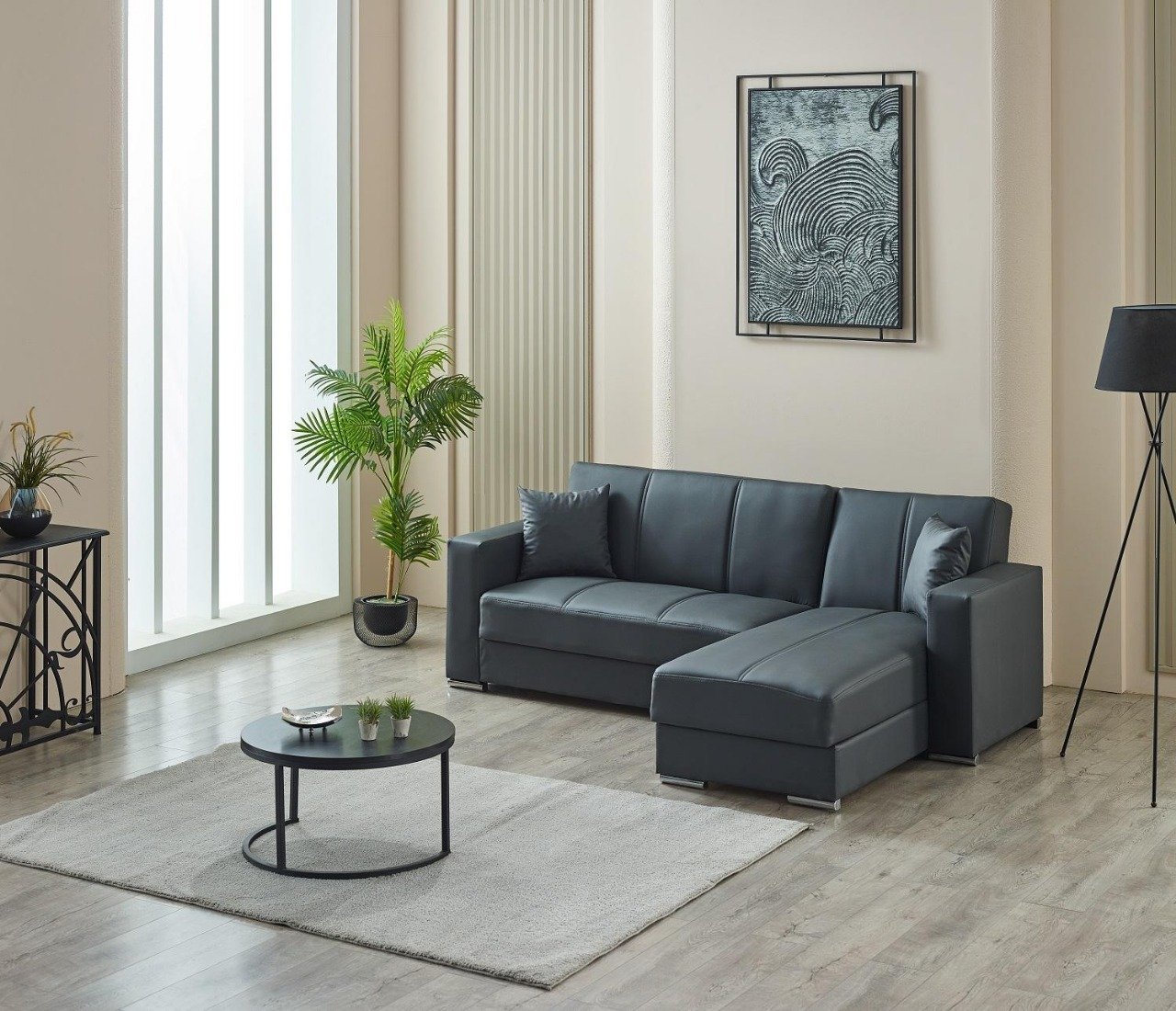 Modern living room with a gray sectional sofa, abstract artwork, and a black coffee table on a gray rug.