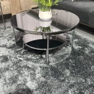 Haven Coffee Table with black glass top and metal frame on a gray rug in a modern living room.