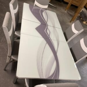 LumiGlide Dining Table with abstract design and six gray upholstered chairs.