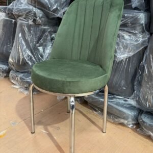 A Majesta Chair with green upholstery and chrome legs in a storage area.
