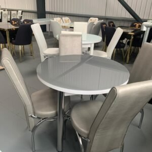 A showroom with various dining tables and upholstered chairs.