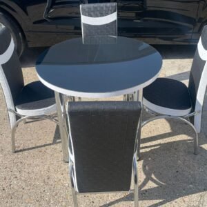 Outdoor furniture set with a round black and white table and four matching chairs.