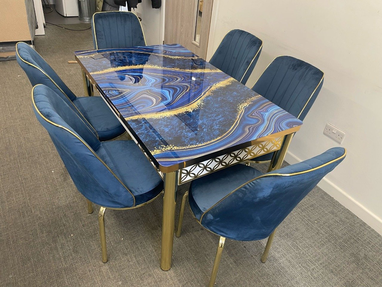 MeadowVale Dining Set with a blue and gold patterned table and six deep blue upholstered chairs.
