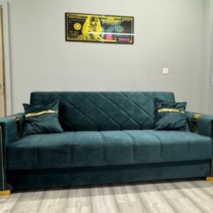 Noir Sofa Bed in dark green velvet with gold accents and decorative cushions.