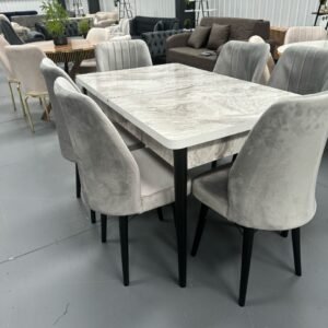 OakHaven Dining Set with a marble-like table and gray upholstered chairs in a showroom.