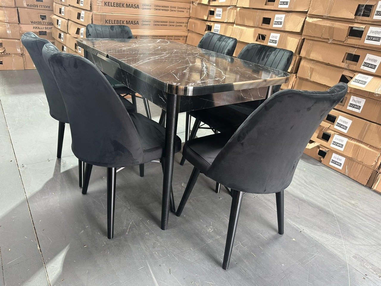 OakHaven Dining Set with a dark marbled table and six dark cushioned chairs in a warehouse setting.