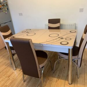 OptraGlass Extendable Table with circular patterns and four chairs in a dining area.