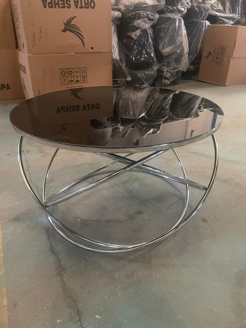 OrbitSilver Coffee Table with a glass top and chrome circular base.