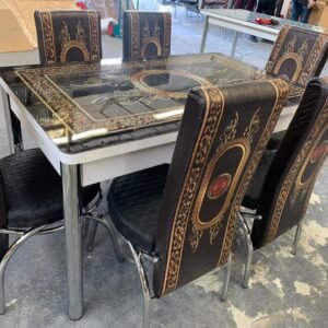 PrismaPull Dining Table with six black and gold patterned chairs in an indoor setting.