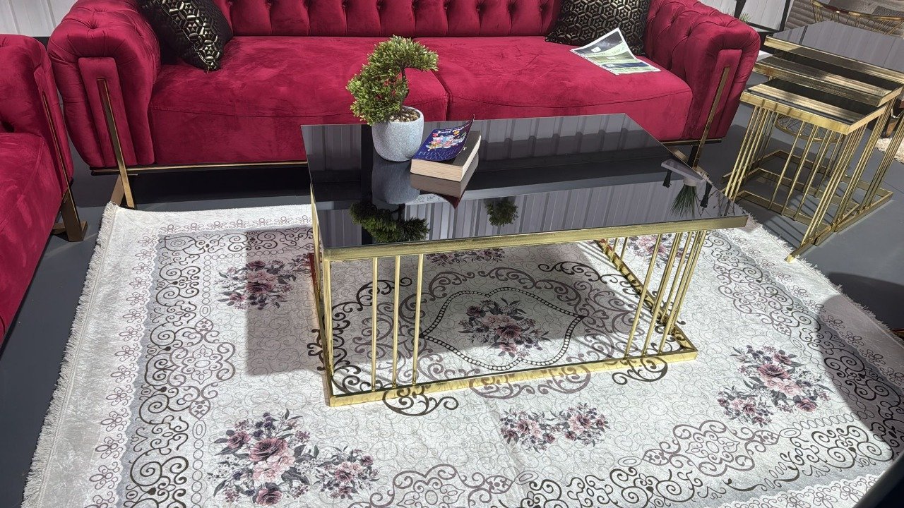 Reeve Coffee Table with a black top and gold legs in a living room.