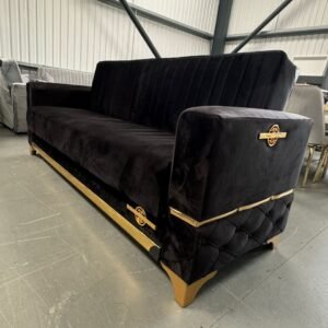 Shadowline Black Sofa Bed with black fabric and gold accents in a room with other furniture.