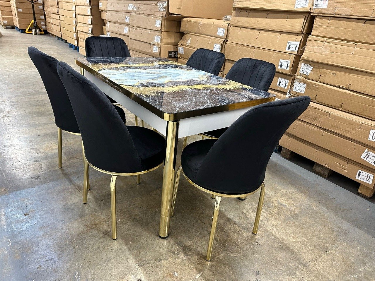 SlateEdge Dining Set with a marbled table and black chairs in a warehouse.