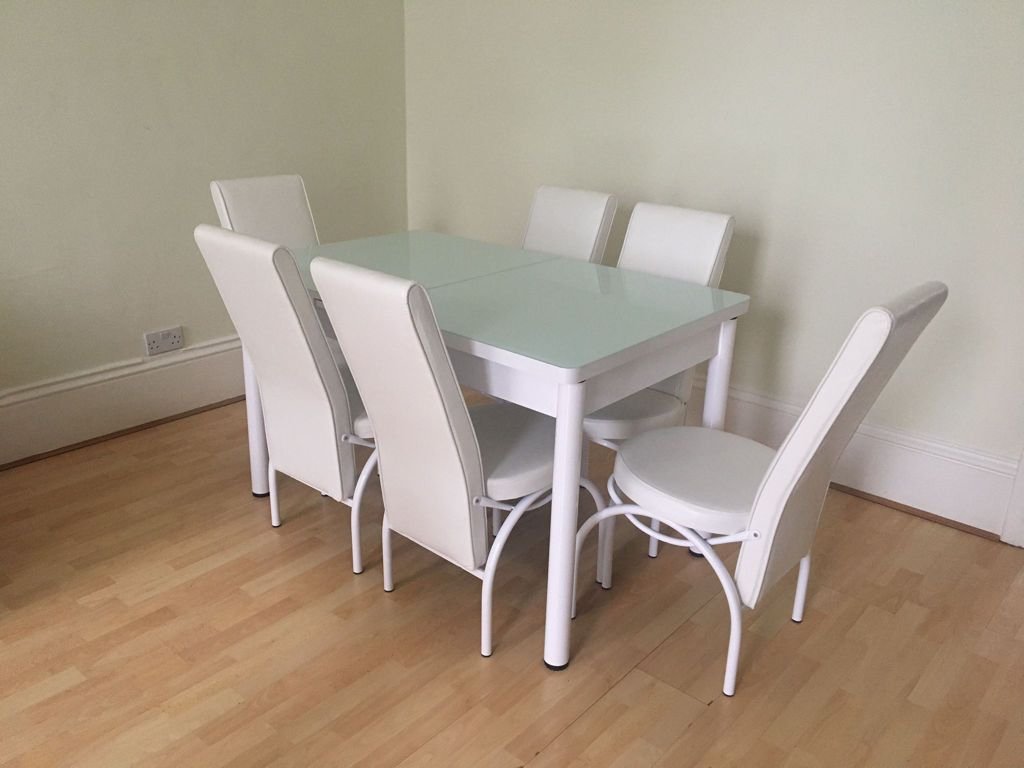 SleekAura Table Set with glass-topped table and six white high-back chairs.
