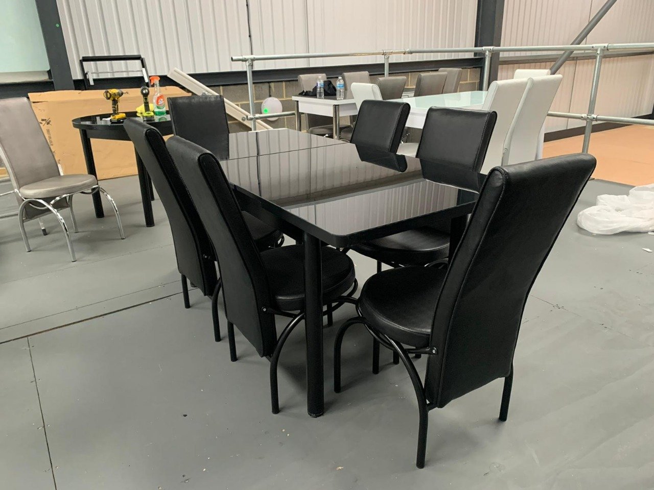 SleekAura Table Set with black glass table and six black upholstered chairs.