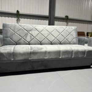 Gray Toscano Sofa Bed with diamond-patterned quilted upholstery and decorative armrests in a spacious room.