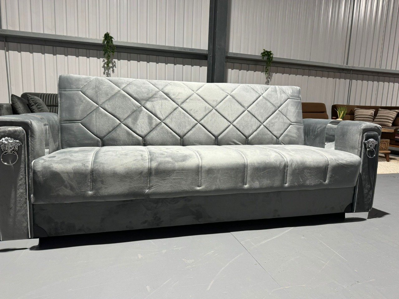 Gray Toscano Sofa Bed with diamond-patterned quilted upholstery and decorative armrests in a spacious room.