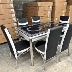 TransparaFlex Dining Table with six black and white chairs in a warehouse setting.