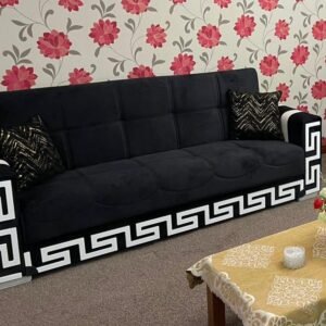 Velvet Noir Sofa Bed with black upholstery and white geometric accents, situated in a floral wallpapered room.