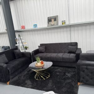 Zara Black Sofa Bed with matching armchairs in a showroom.