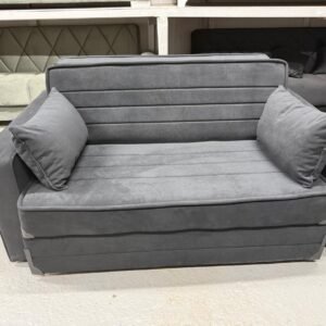 A dark gray, modern sofa with horizontal stitching and two matching cushions.