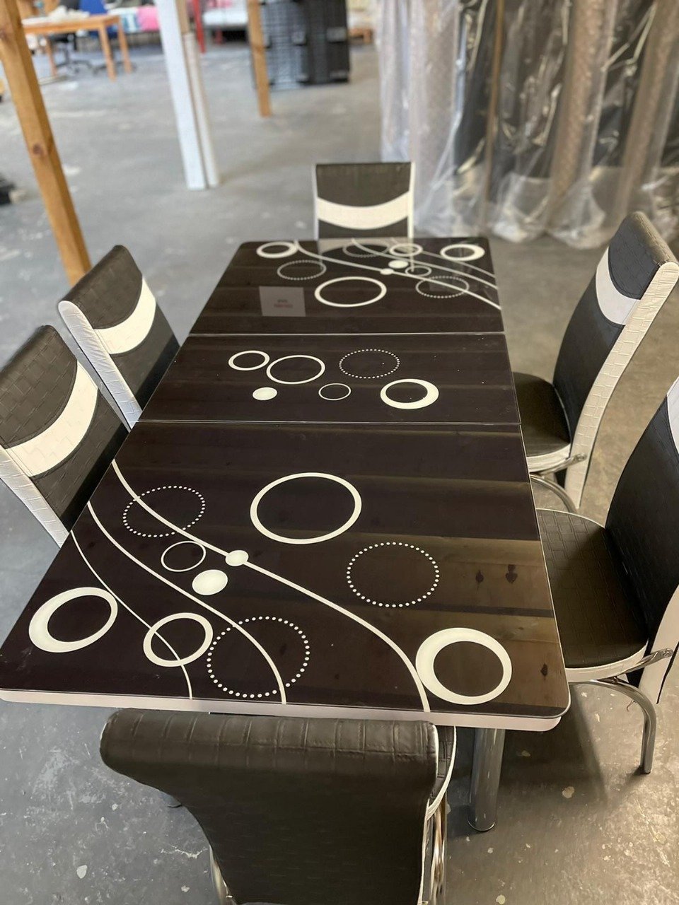ZenArc Dining Set with a dark tabletop featuring white circular designs and six matching chairs.
