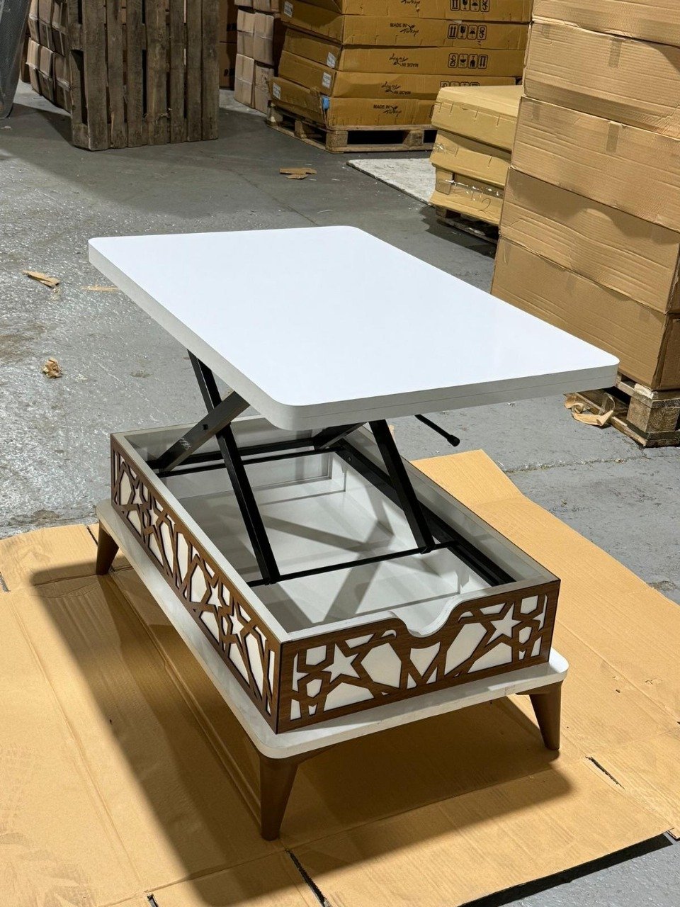 White convertible table with liftable top and decorative panels.