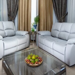 Living room with two gray sofas and a glass coffee table with a fruit bowl.