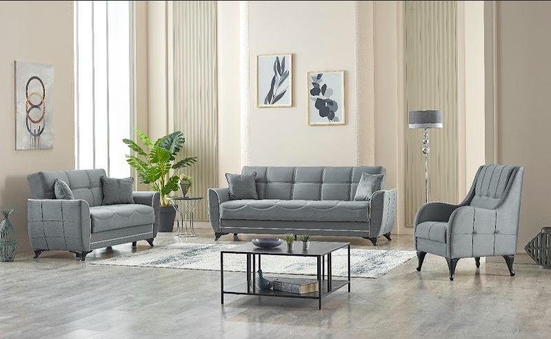 Modern living room with a gray sofa, matching armchairs, a coffee table, and wall art.