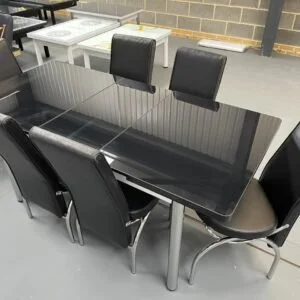 CrystalArc Extendable Dining Table with black glass top and six black leather chairs.